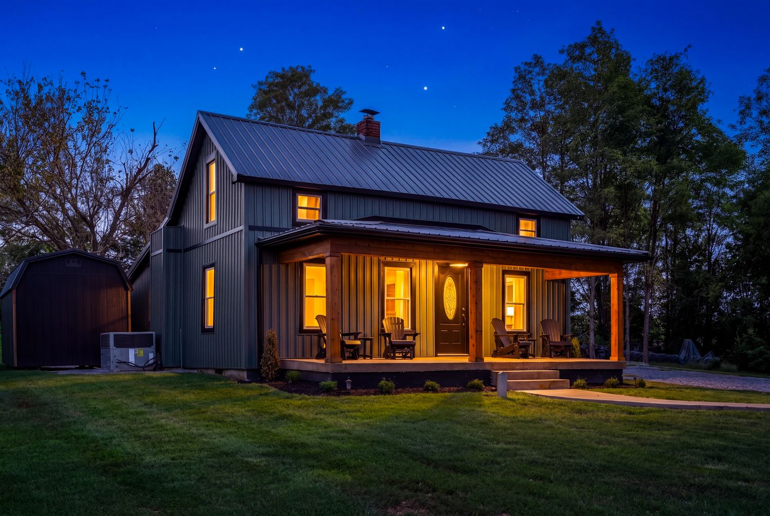 The Cedar and Sage farmhouse at dusk, windows lit.